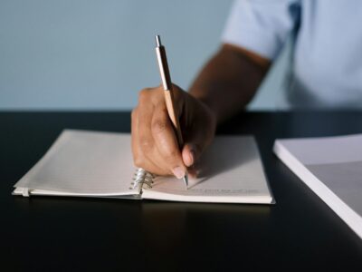Close-Up Shot of a Person Writing on a Notebook